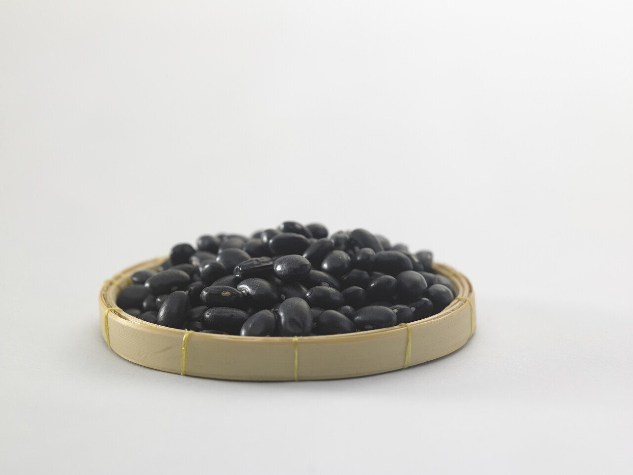 白色背景上的秸秆托盘黑豆