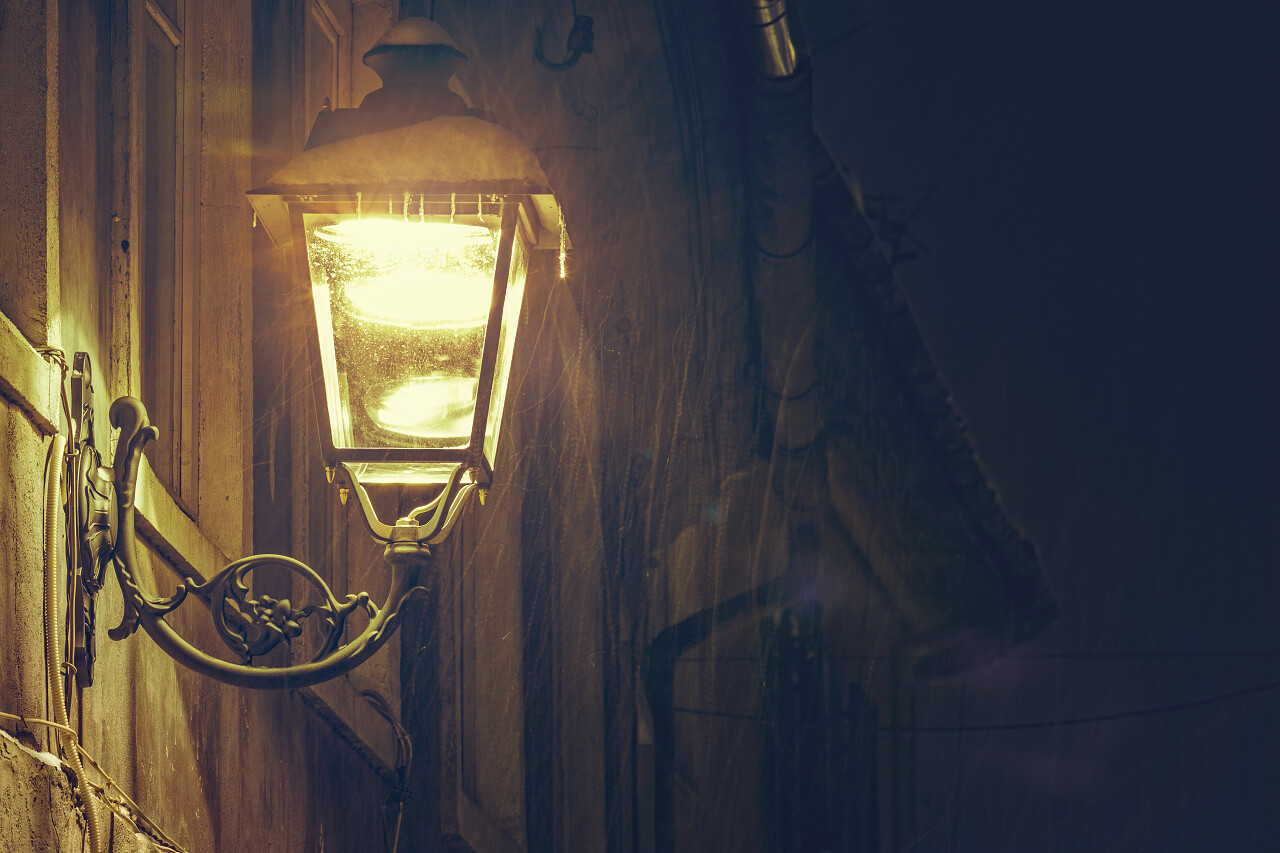 雪色夜景下建筑外墙发光的老式铁路灯图