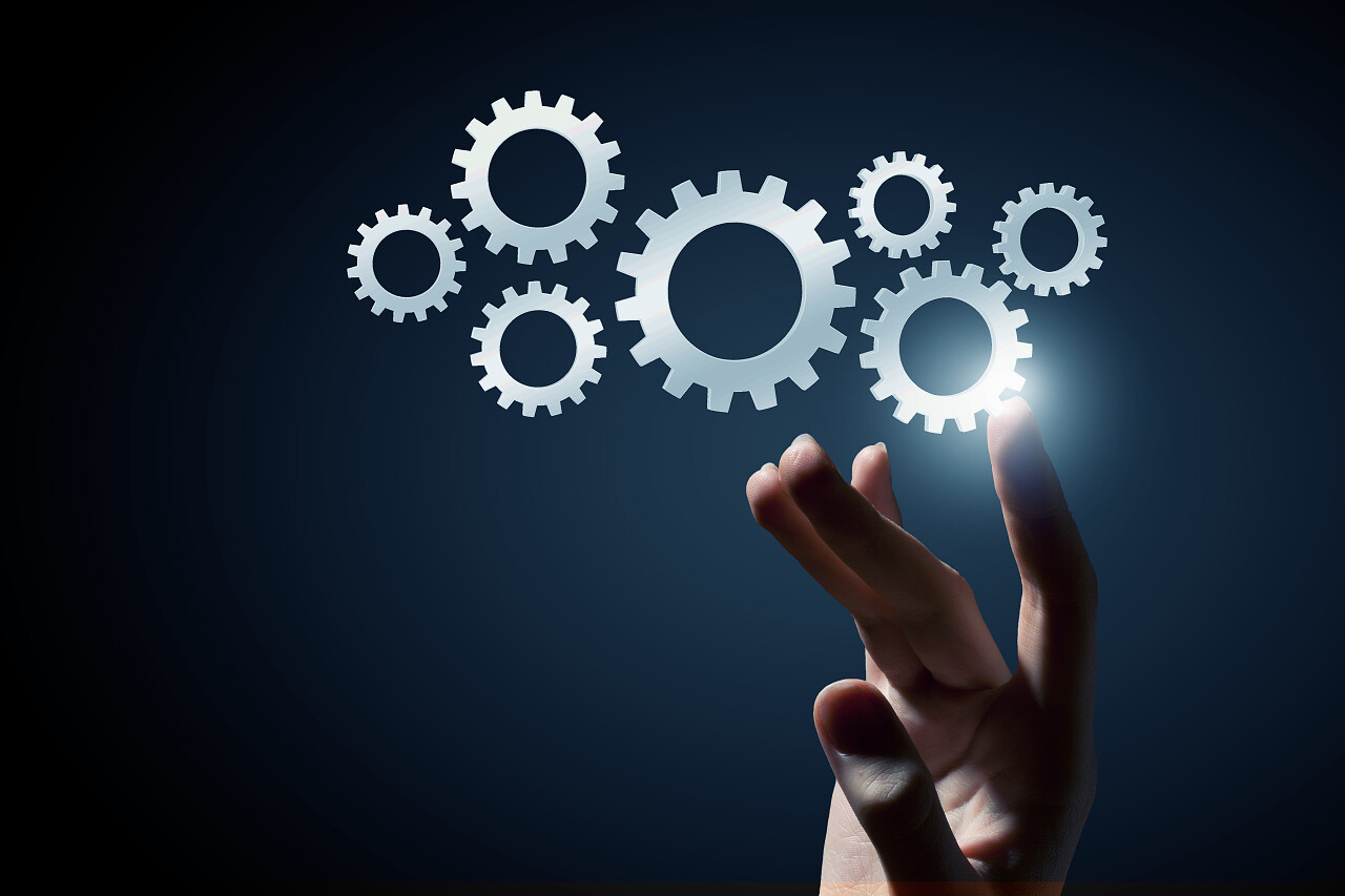 黑色背景下业务人员用手抚摸齿轮机构