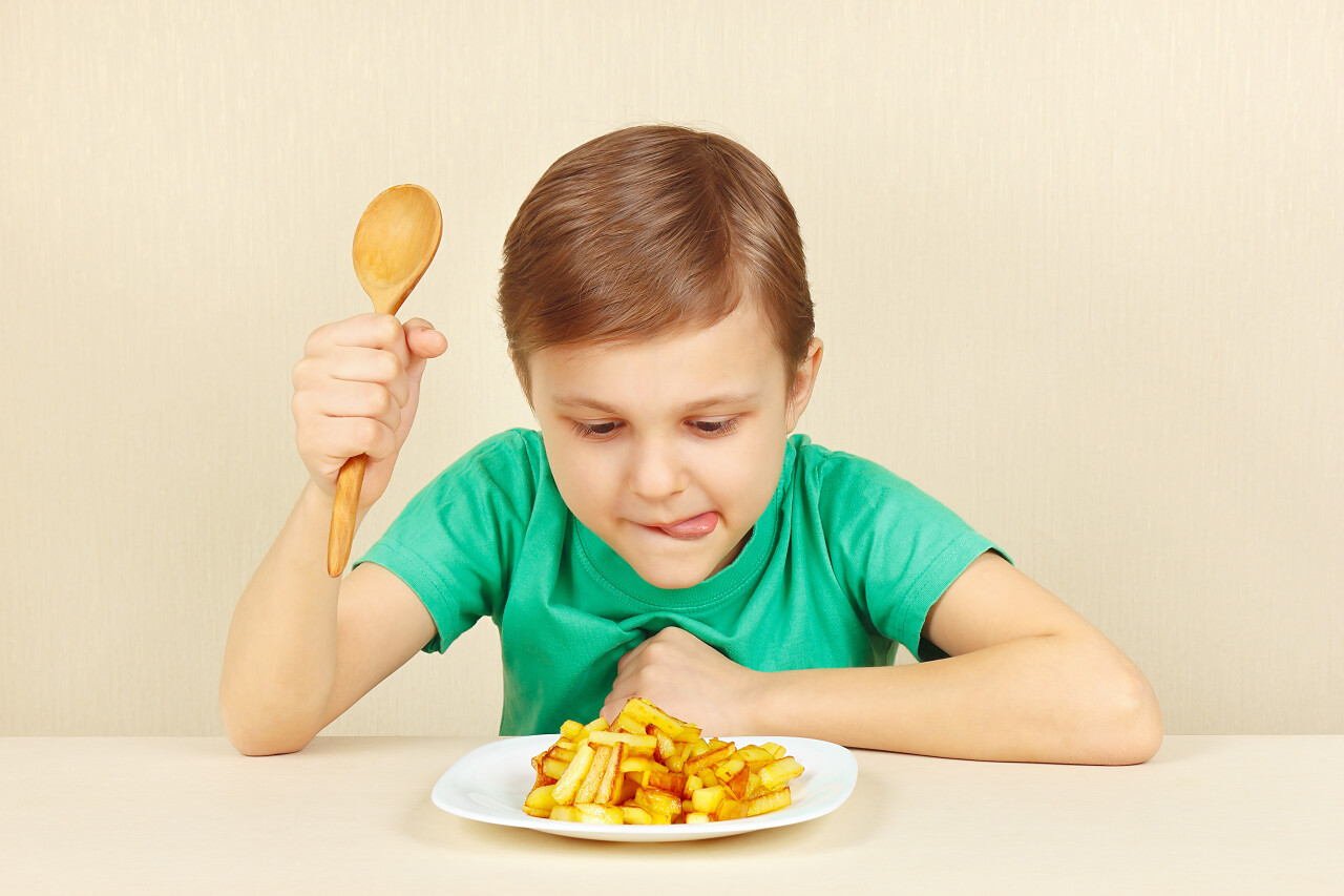 小男孩正在吃美味的油炸土豆