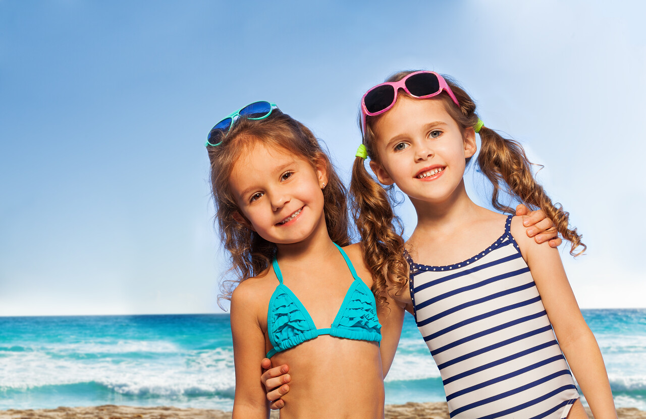 穿着泳装戴着太阳镜的两位小朋友在海边玩耍幸福童年 孩子幸福的人美好童年