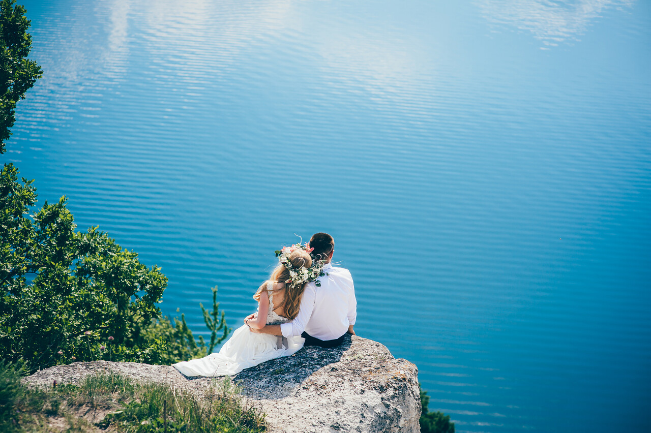 年轻的新婚夫妇与蓝蓝的天空背景合影