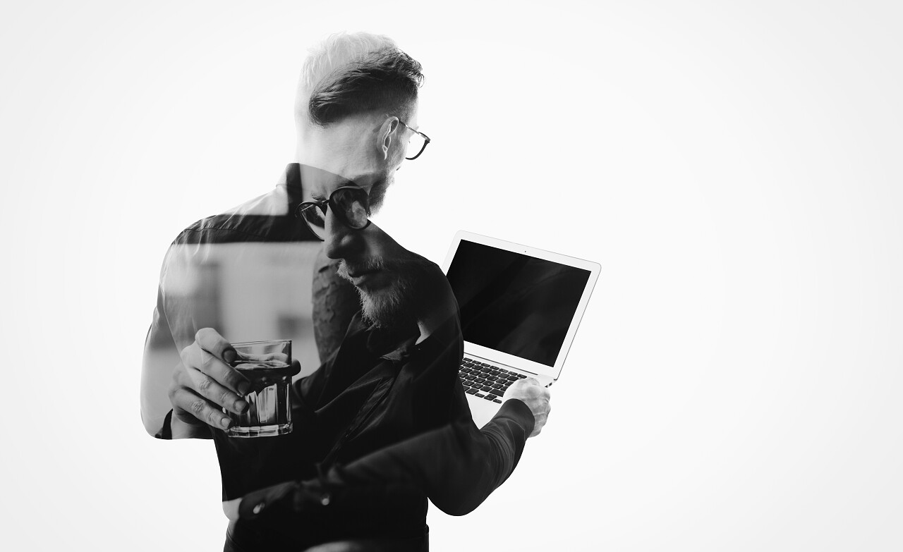 白色背景上站着一个商务男性正在看着手中的电脑