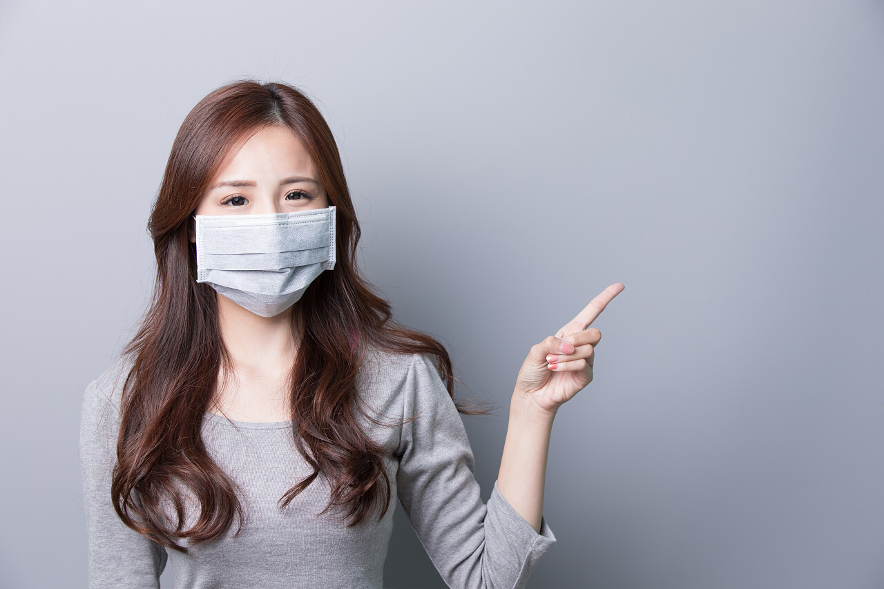 一个女人生病戴着口罩