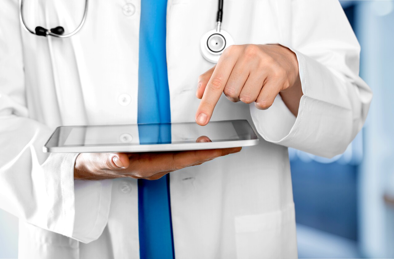 与平板电脑一起工作的医生特写