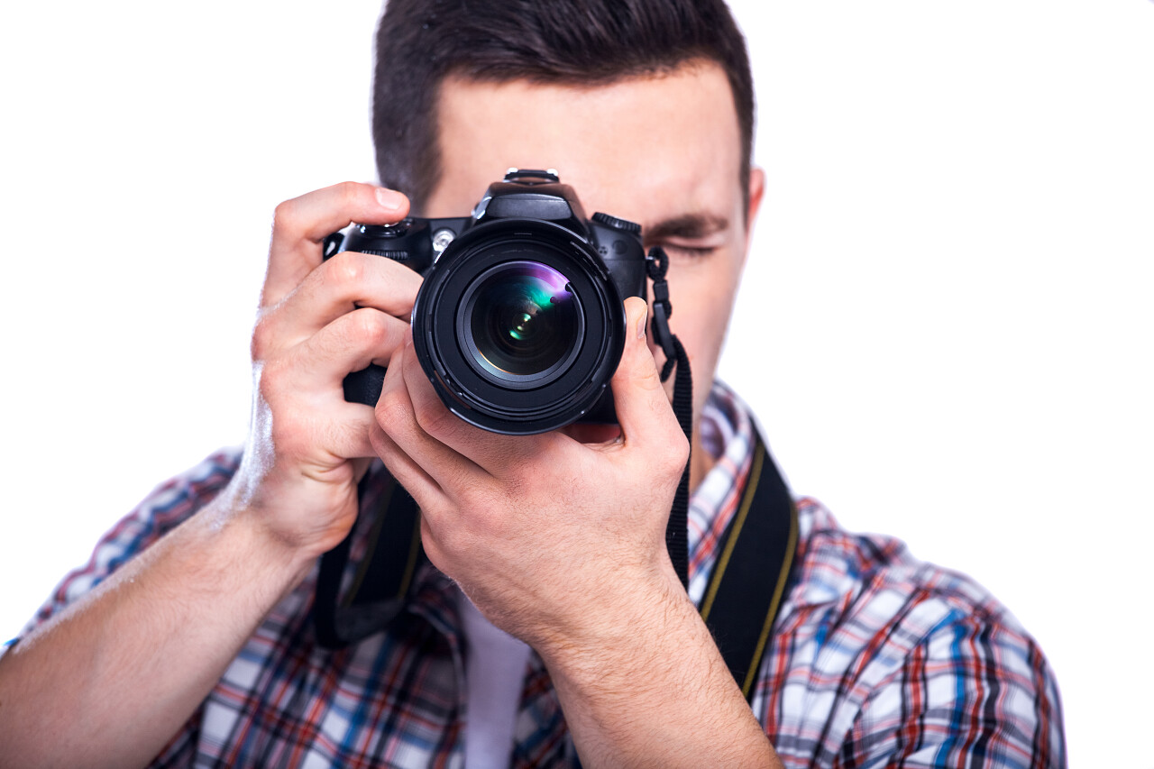 一个年轻男人正在拿着照相机拍照