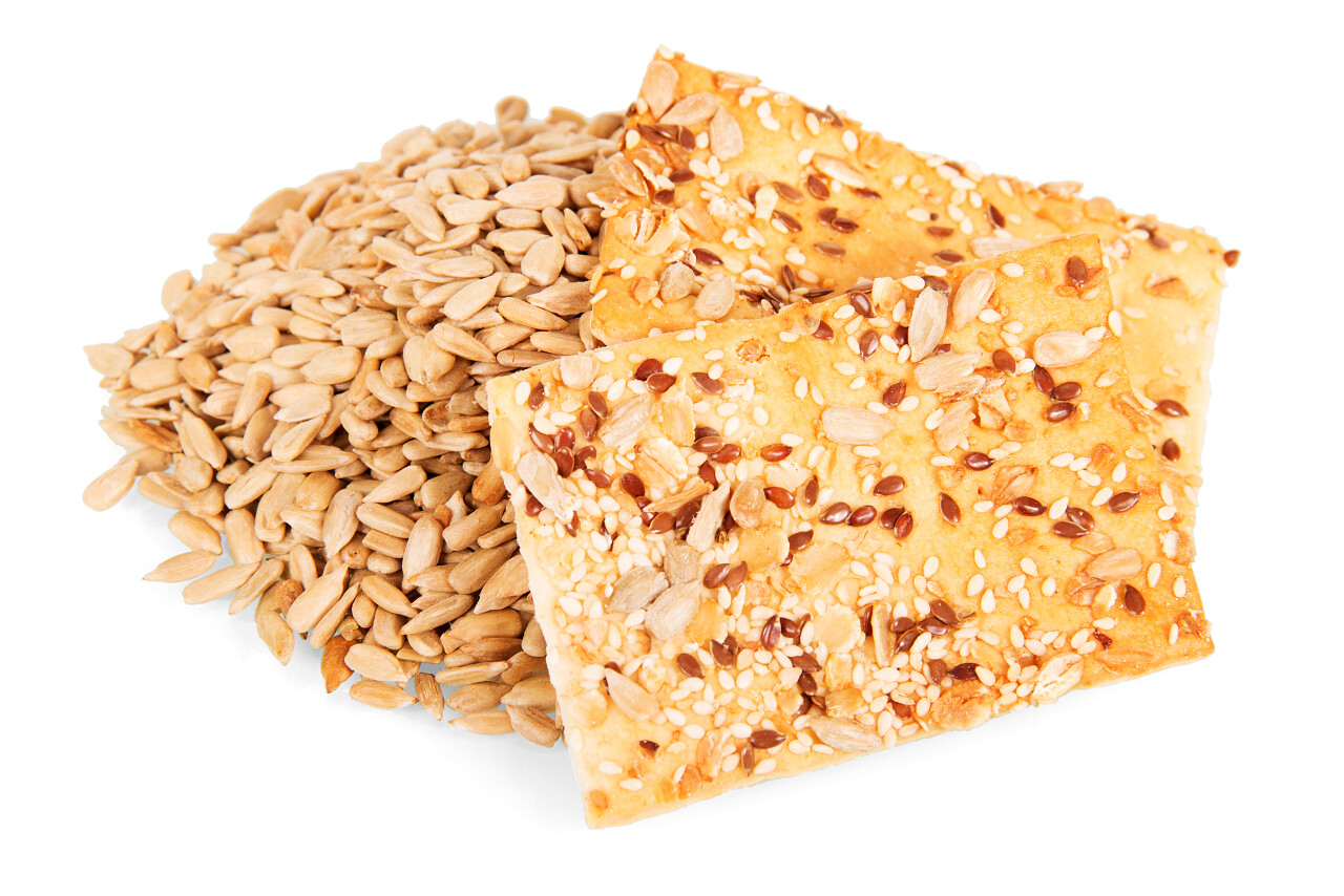 孤立在白色背景上的向日葵种子和脆脆饼干.