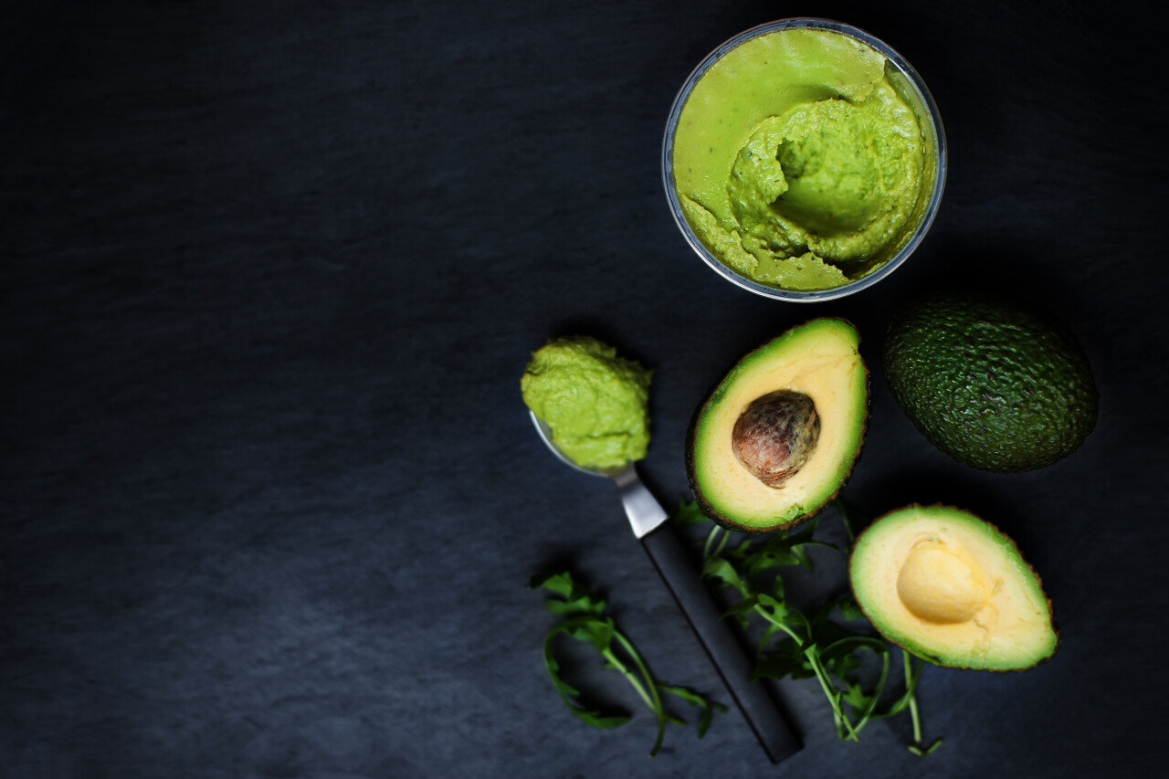 黑色的桌面上摆放着绿色的牛油果