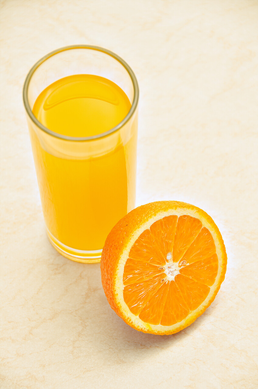 新鲜橙汁切开橙子一杯橙汁橙色液体果汁背景图片