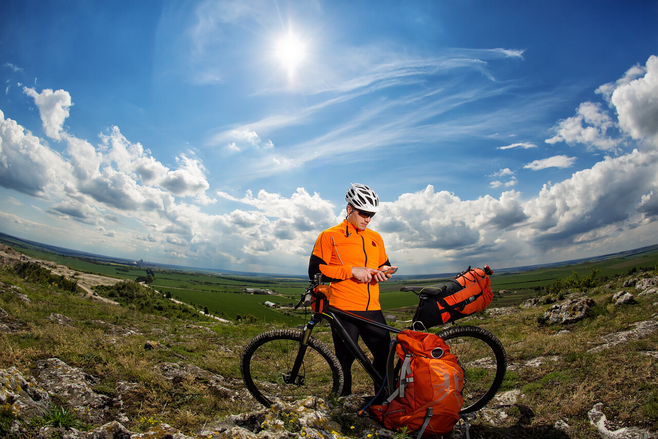 户外运动骑行蓝天下马路上骑山地车的男子