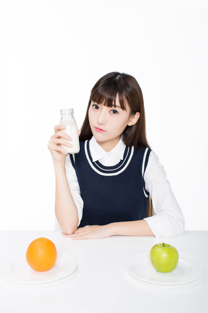 女孩举着牛奶喝牛奶苹果橘子营养早餐健康饮食