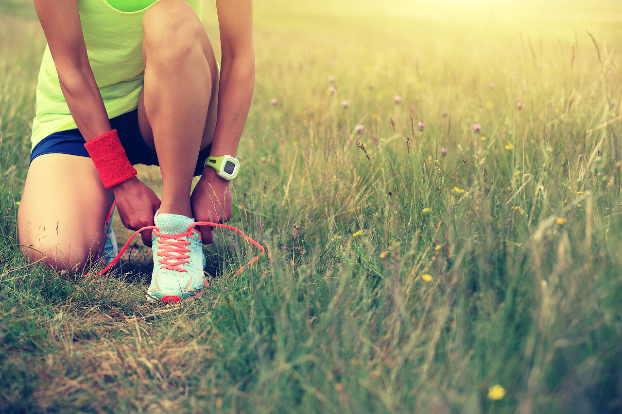 系鞋带的女人户外越野跑在夏天阳光锻炼健身健康