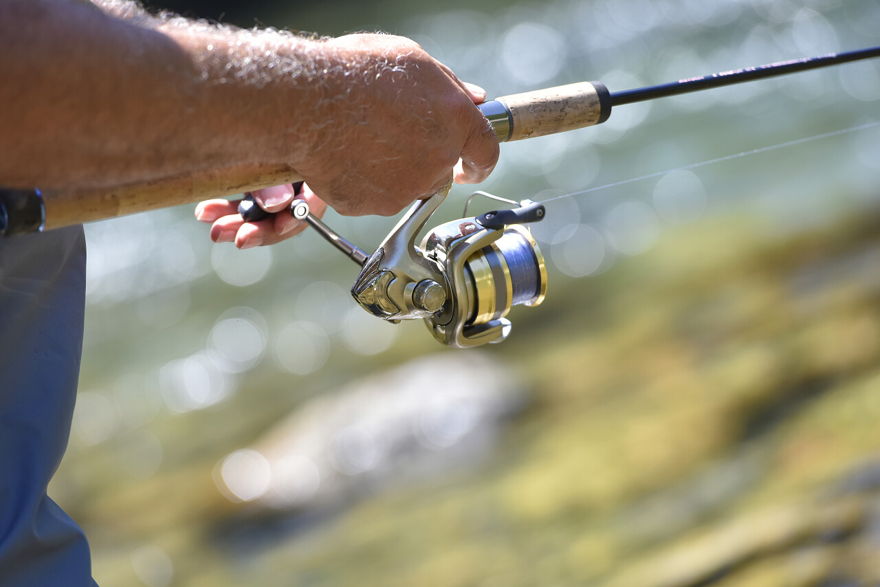 钓鱼鱼竿手拿鱼竿垂钓海边水边模糊背景
