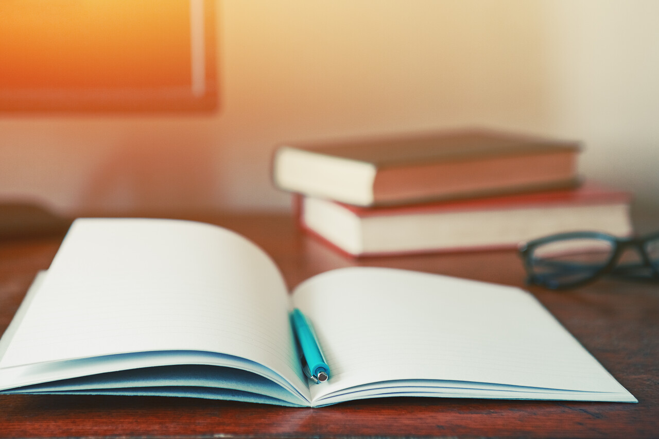 书上的眼镜打开的书钢笔书桌