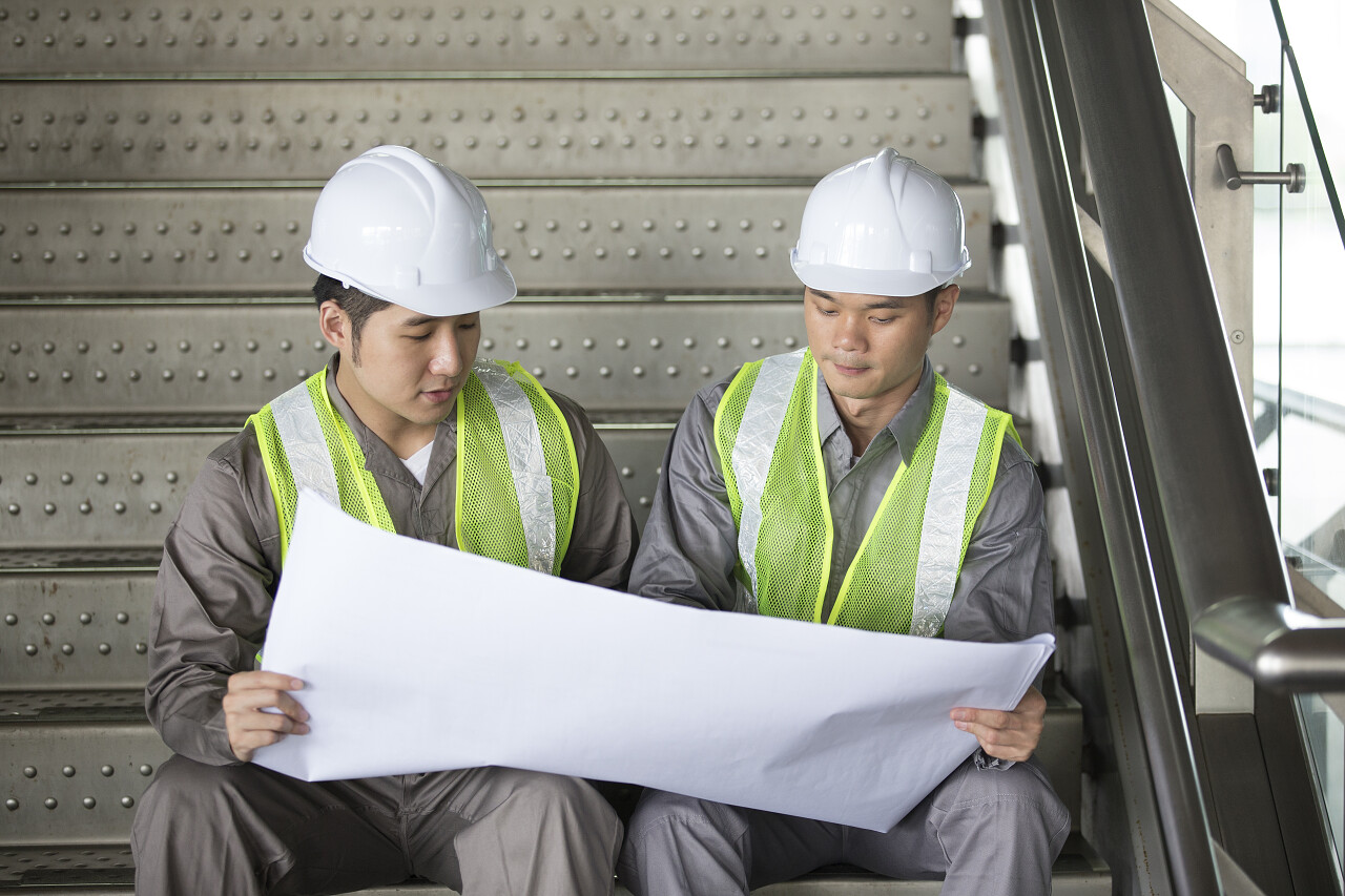 建筑工地施工现场建筑工人研究图纸工人讨论指导工作