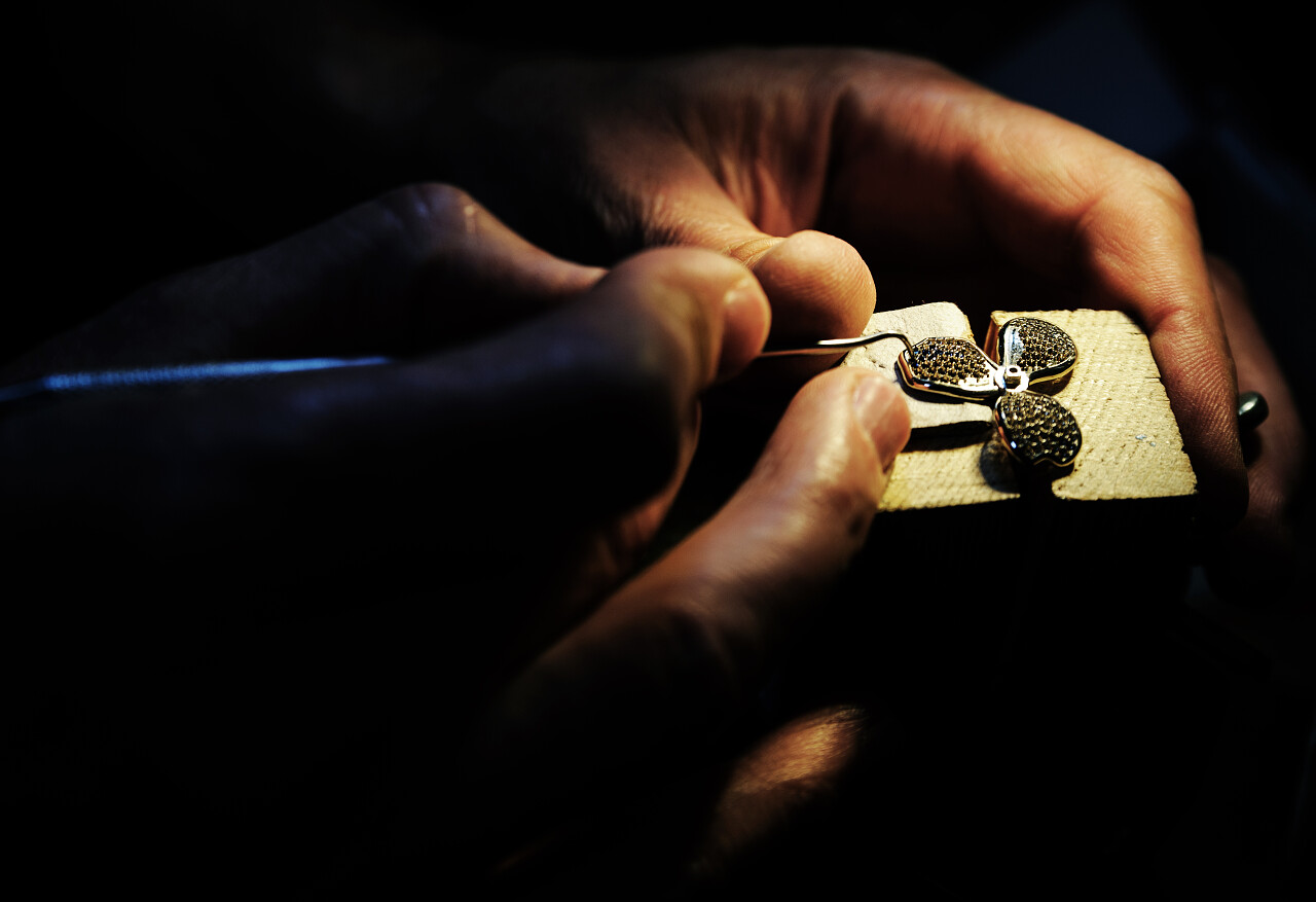 一个人在修复戒指上的蓝宝石