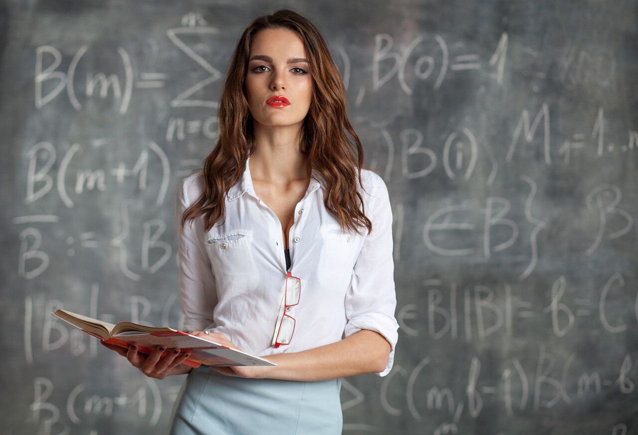 一个年轻聪明的女人在黑板前思考着