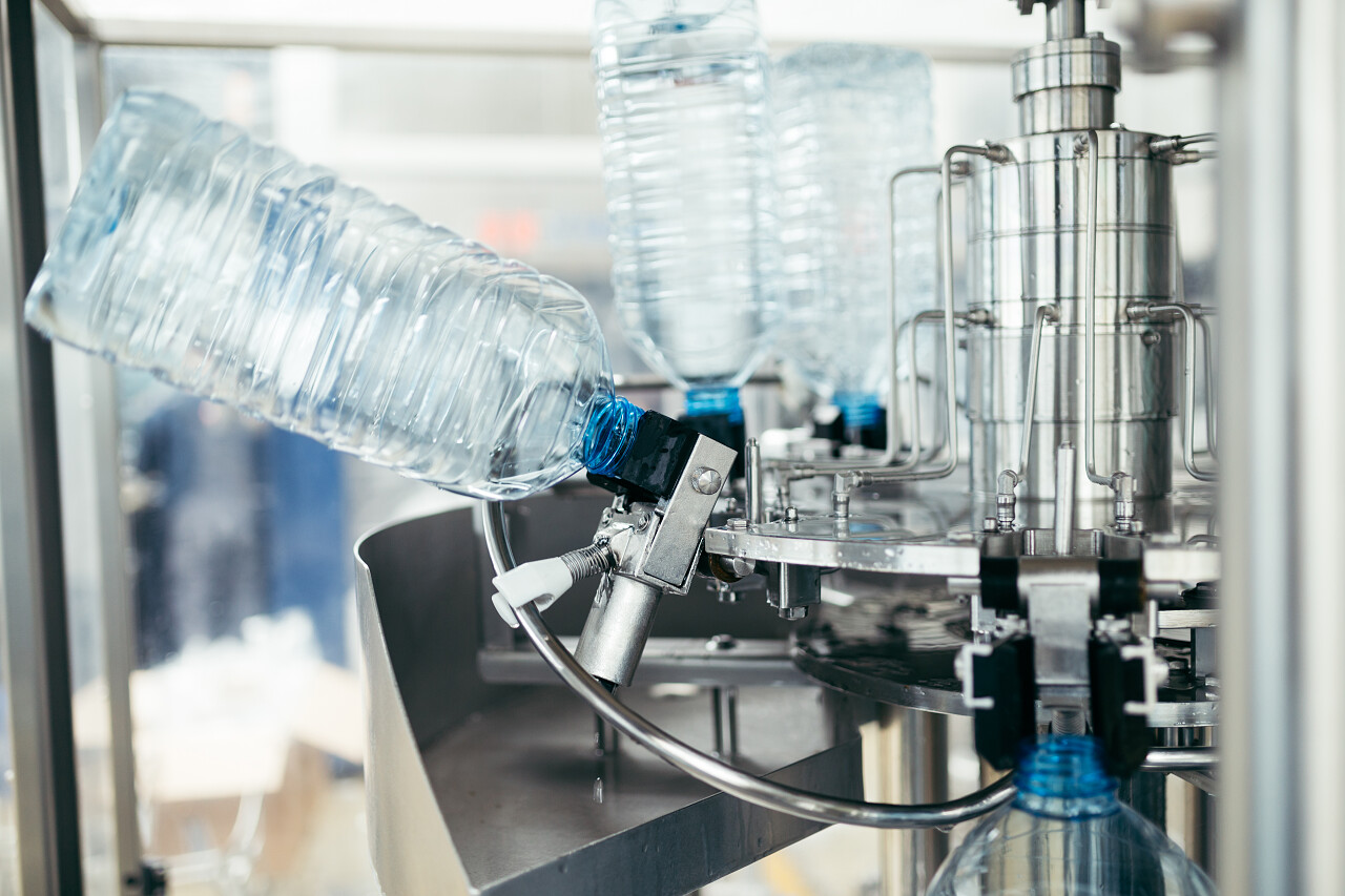 为处理和质量控制的纯净的泉水瓶装小罐里的机器人工厂流水线