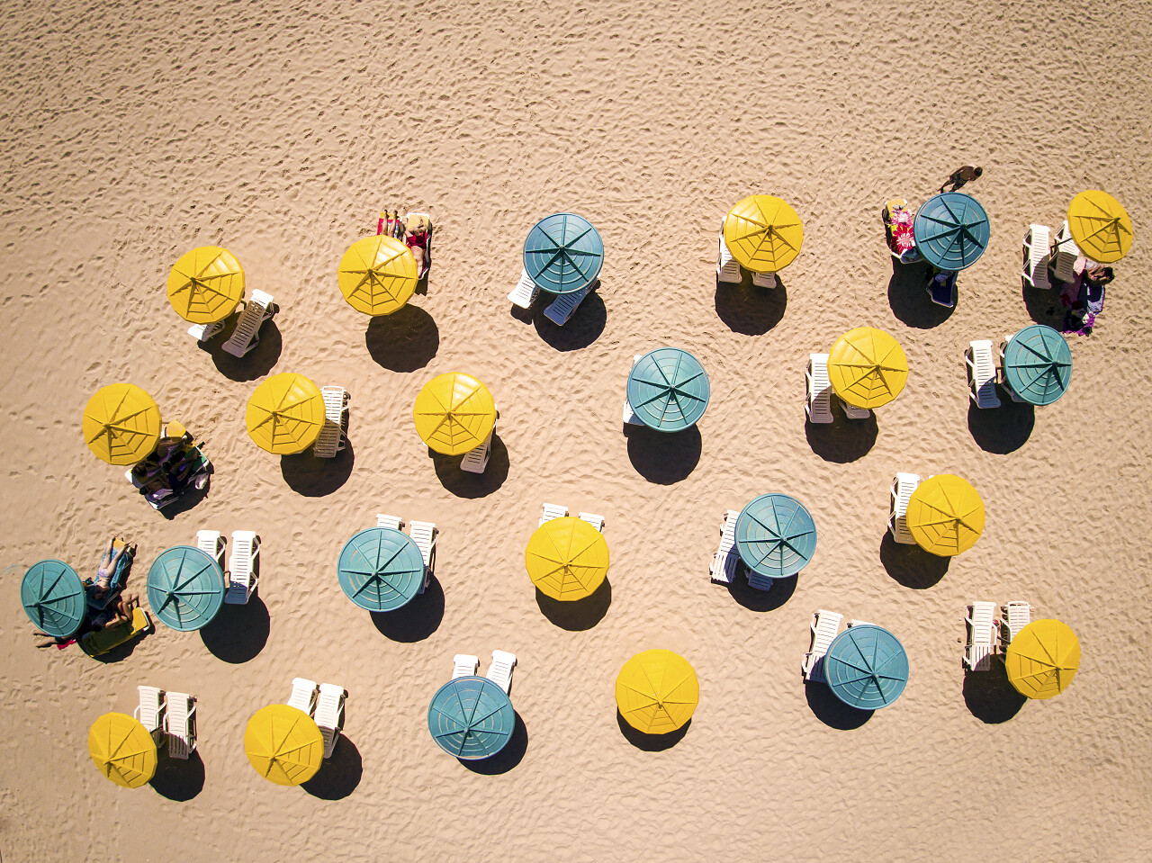 日光浴浴床和遮阳伞在热沙上放松放松