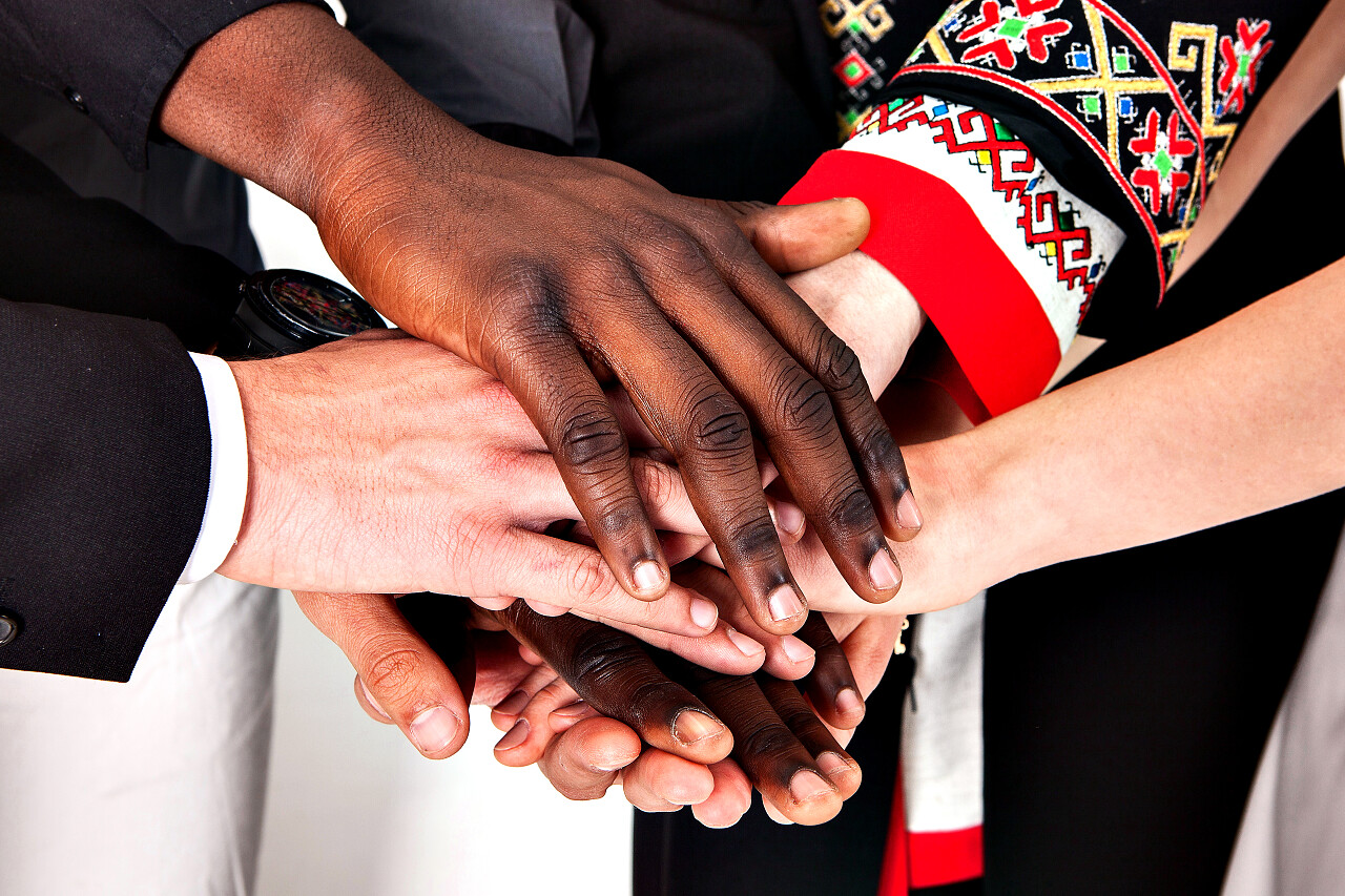 不同的民族和宗教的人牵手团队加油