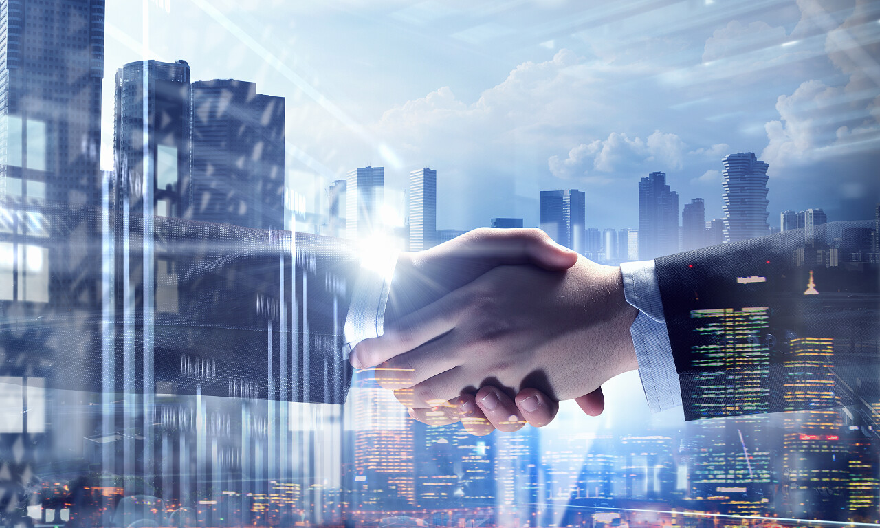 在背景下两位商务人士正在握手合作团结握手企业团结团结合作平台商务人士合作握手