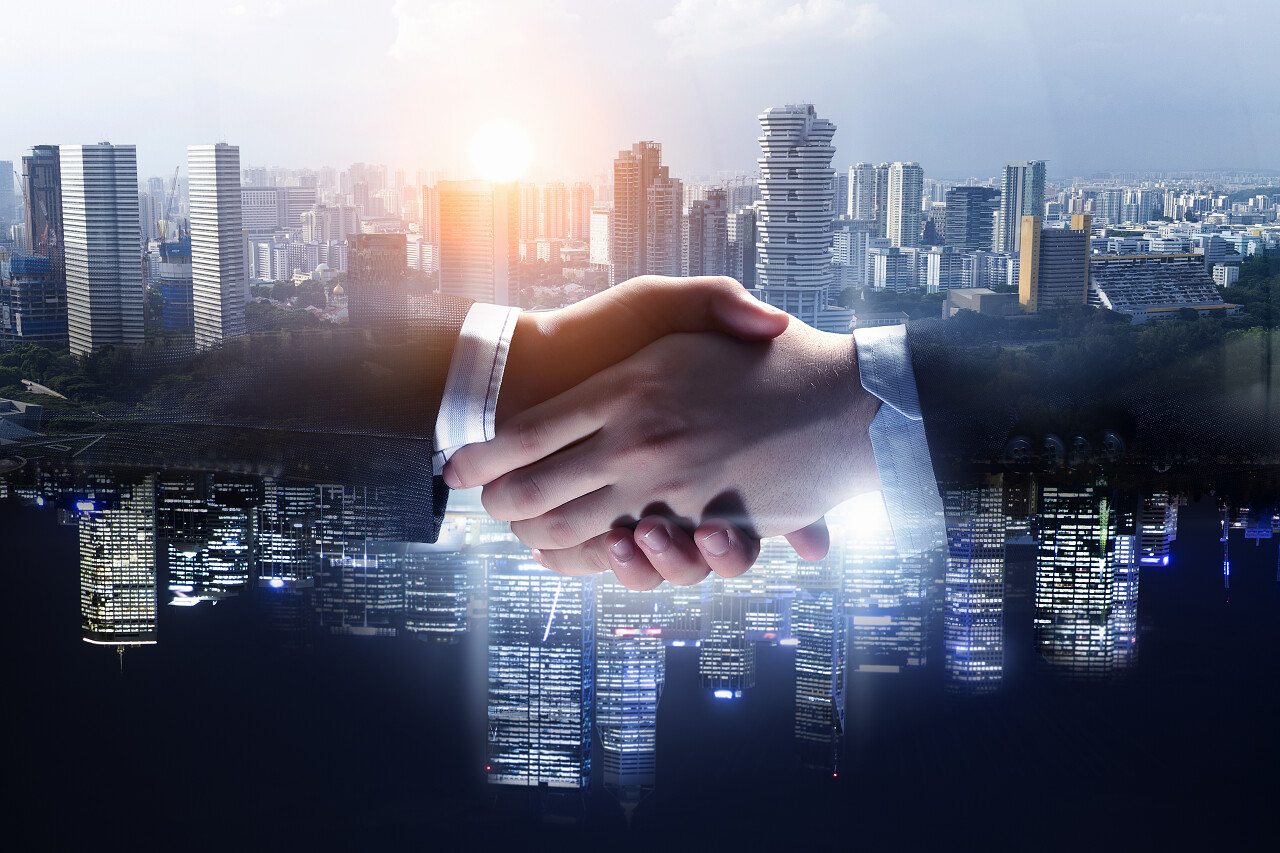 在城市背景下两位商务人士正在握手合作团结握手企业团结团结人物合作平台商务人士合作握手