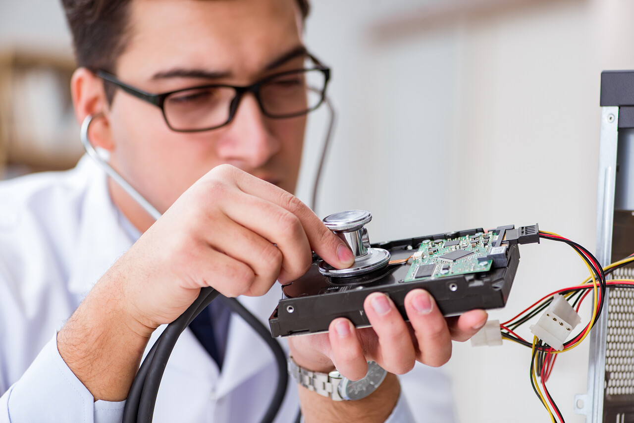 一位医生正在用听诊器见检查硬盘驱动器