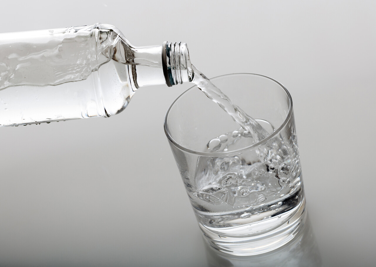 白色背景上放着玻璃杯和瓶装水