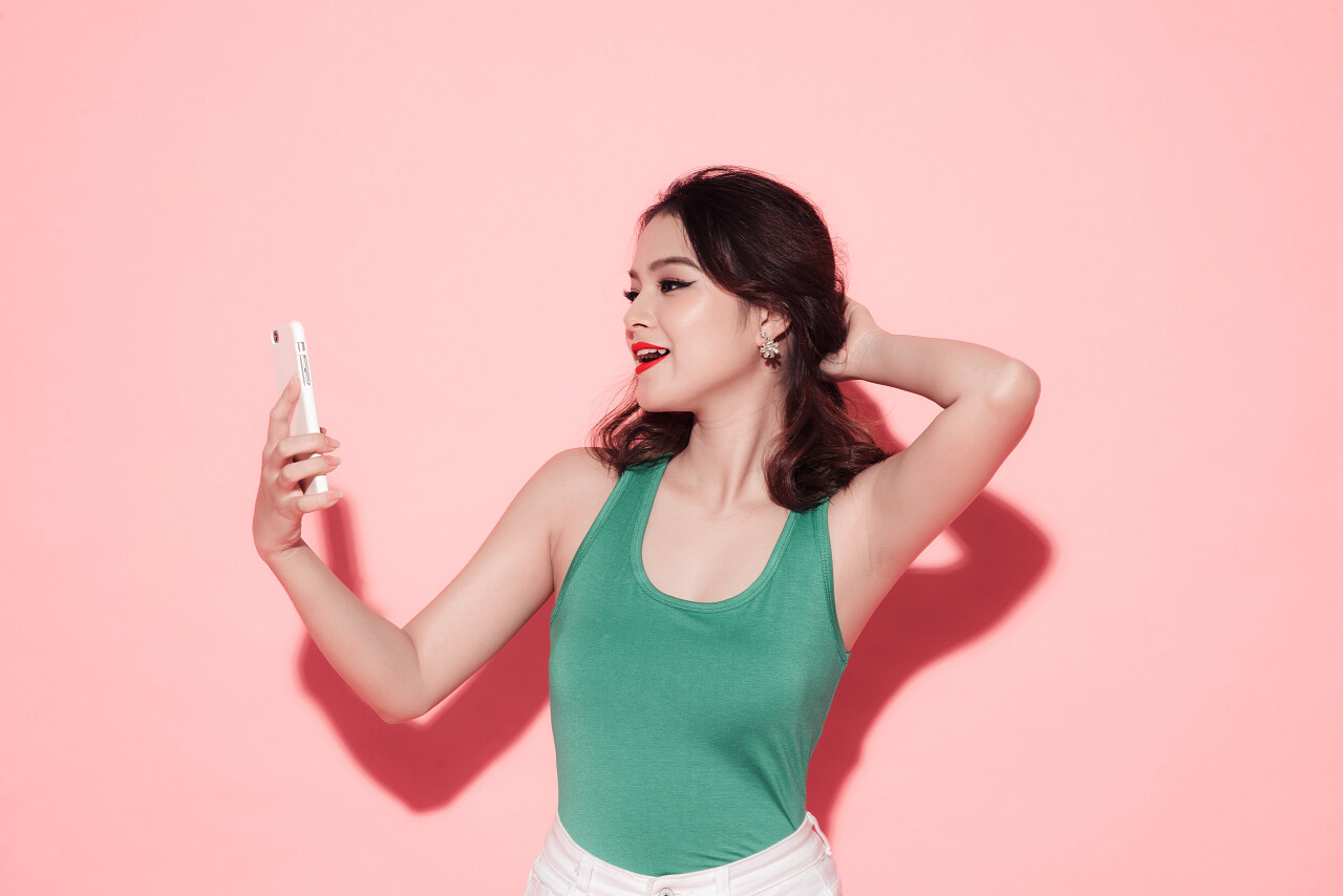 粉色背景下的打扮时髦的女性