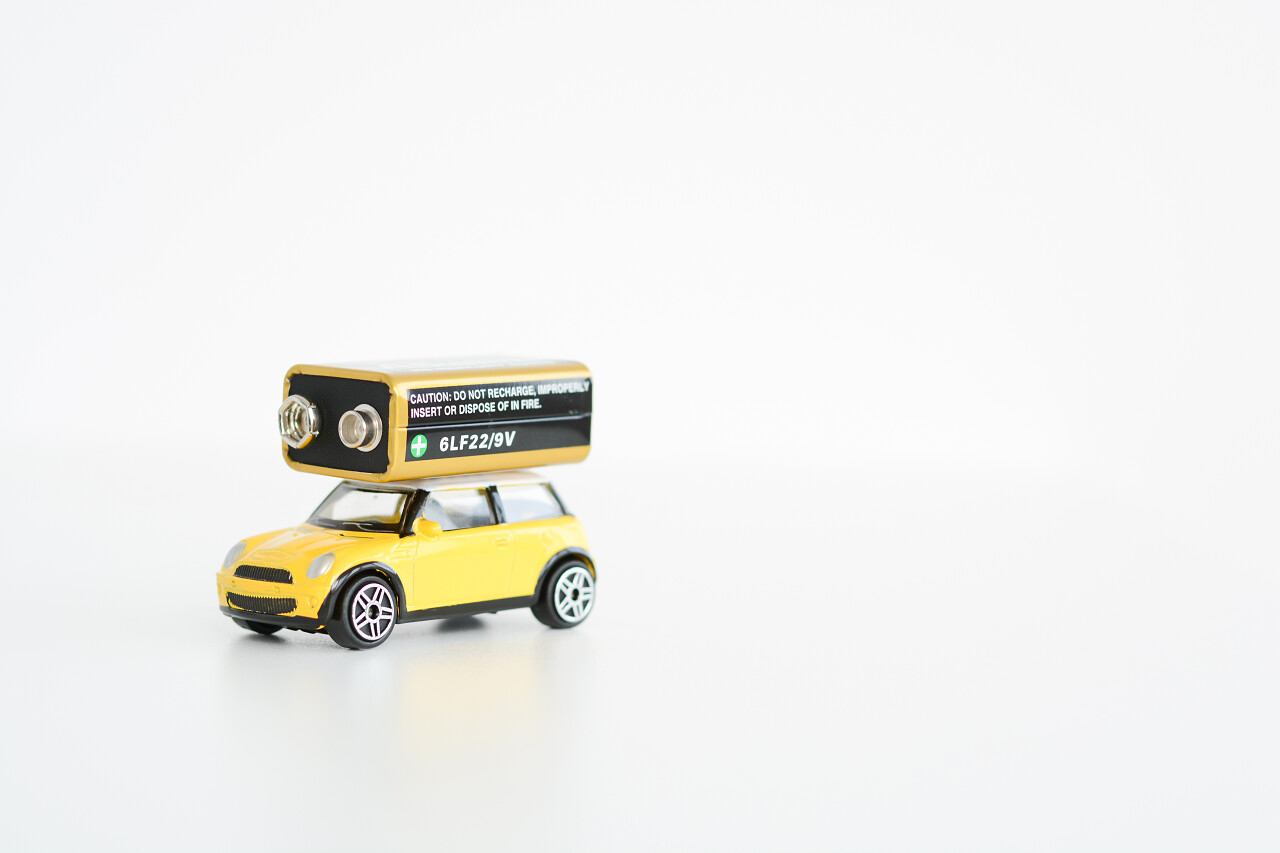 放在白色背景上的电池和汽车模型环保新能源电池