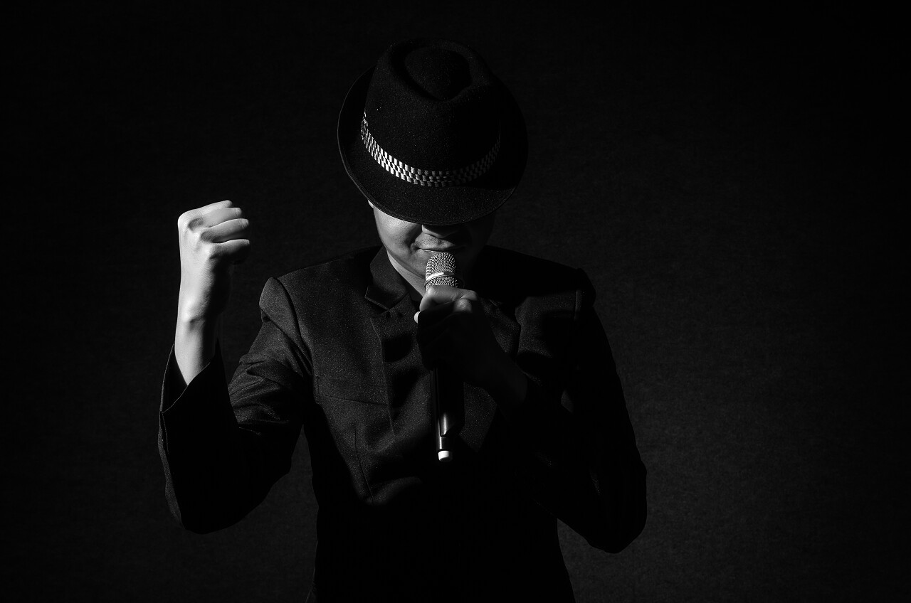 歌手手持话筒和在黑色背景上歌唱