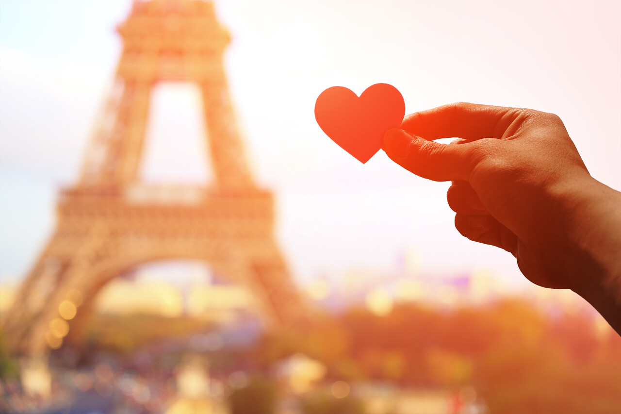 浪漫情侣手持有爱的心纸与埃菲尔铁塔在巴黎与夕阳的剪影幸福情侣幸福的人日记情人节