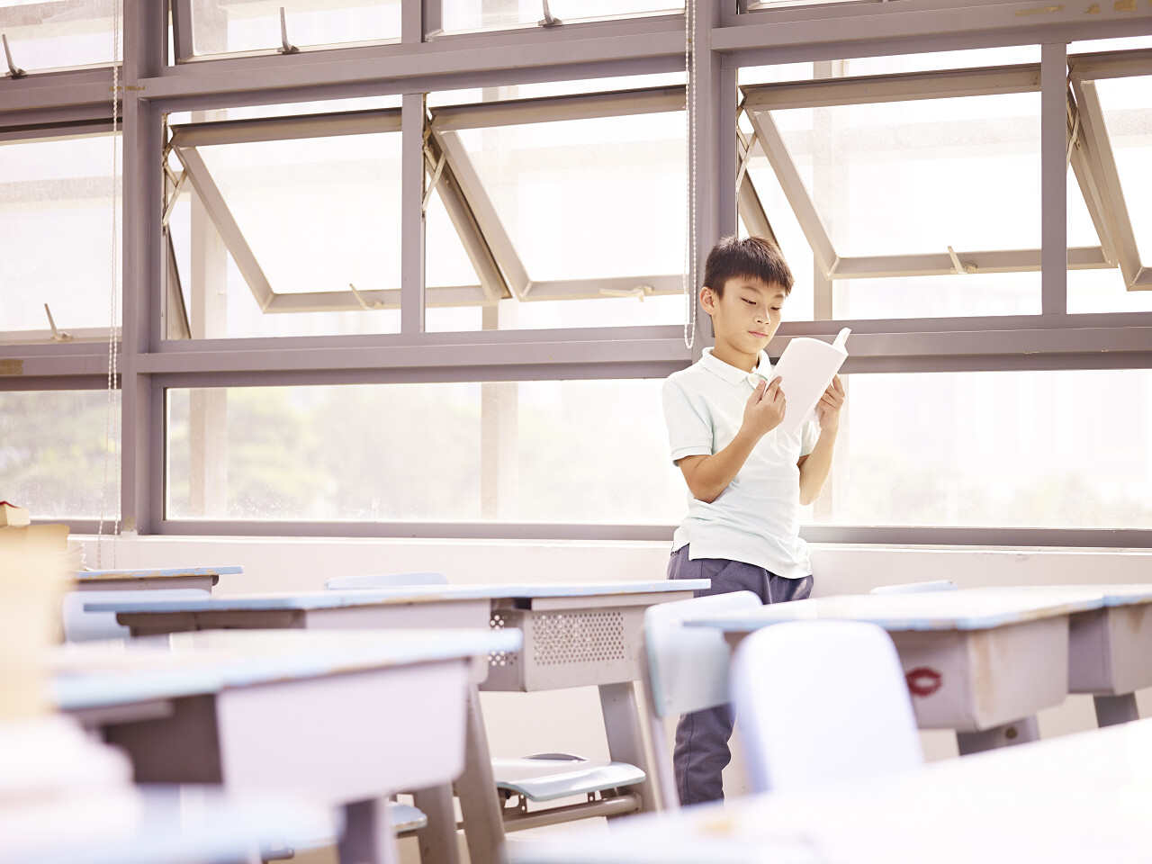 一名学生在阳光下的教室内学习