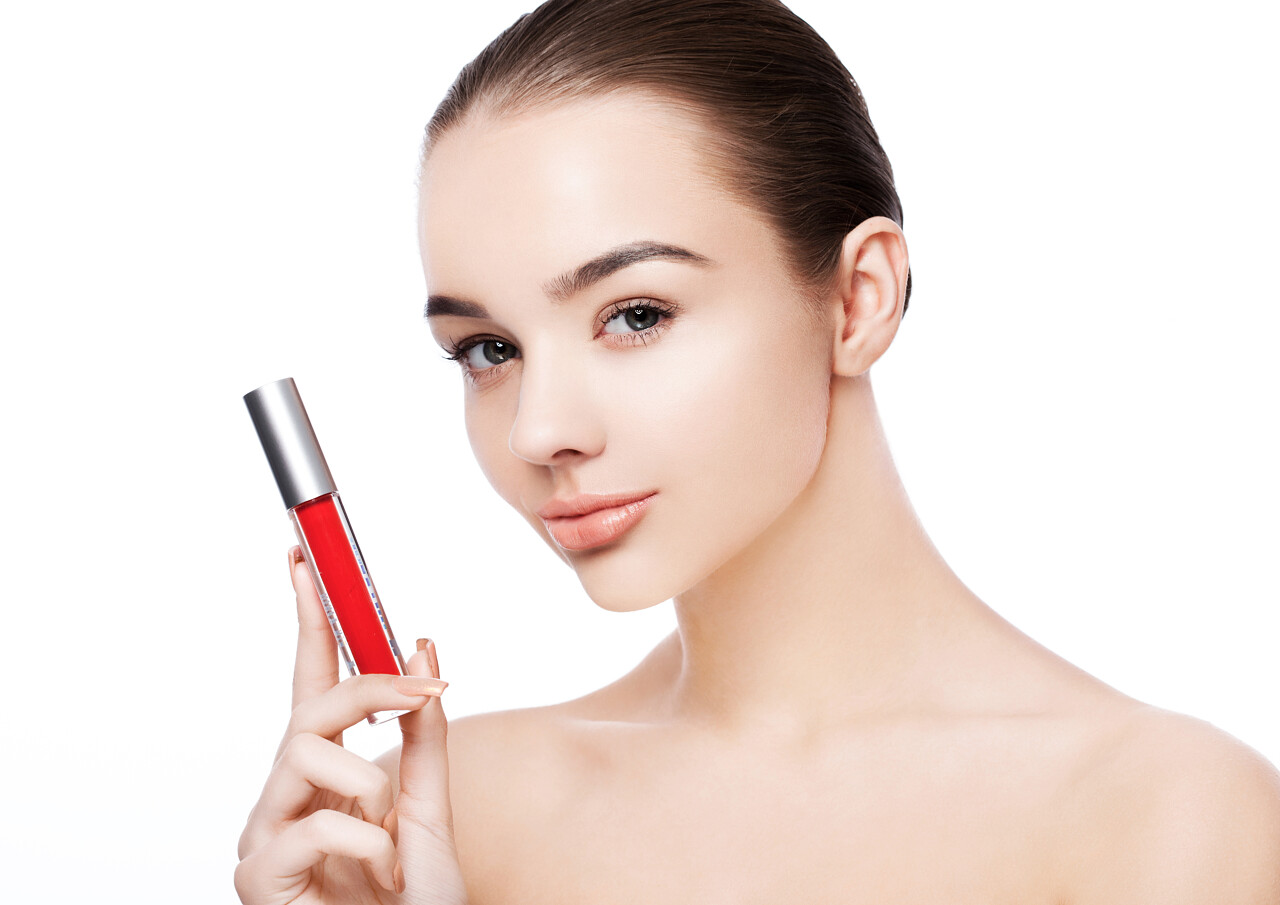 拿着唇膏的年轻美女嘴唇