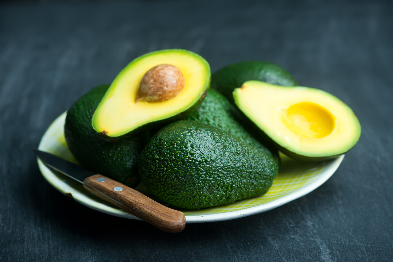 黑色桌子上盘子中的牛油果