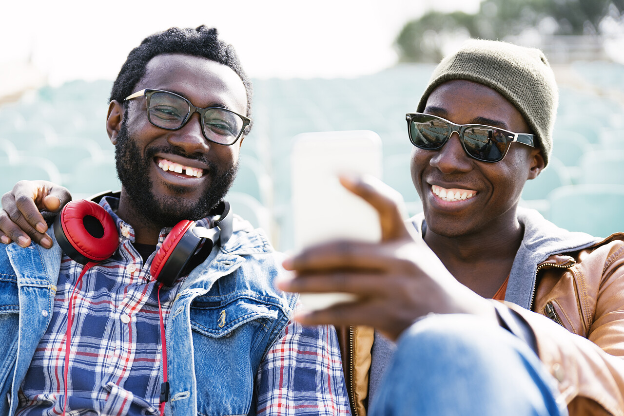 两个黑人朋友玩手机朋友的概念