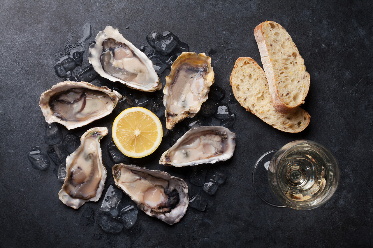 打开牡蛎冰和柠檬配白葡萄酒在石桌