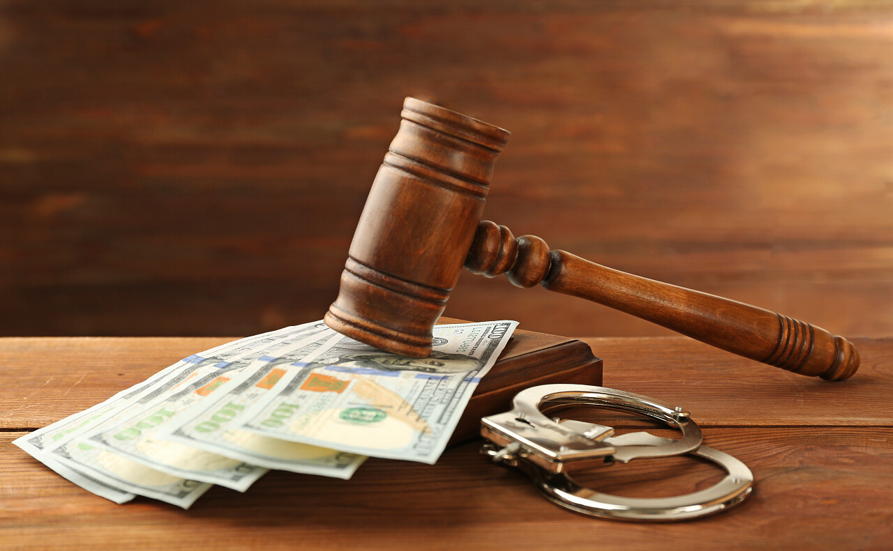 法律法官的木槌和木制背景上的钱