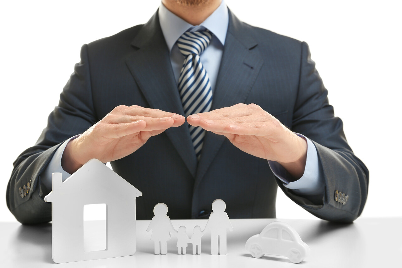 男子手盖在玩具房子上