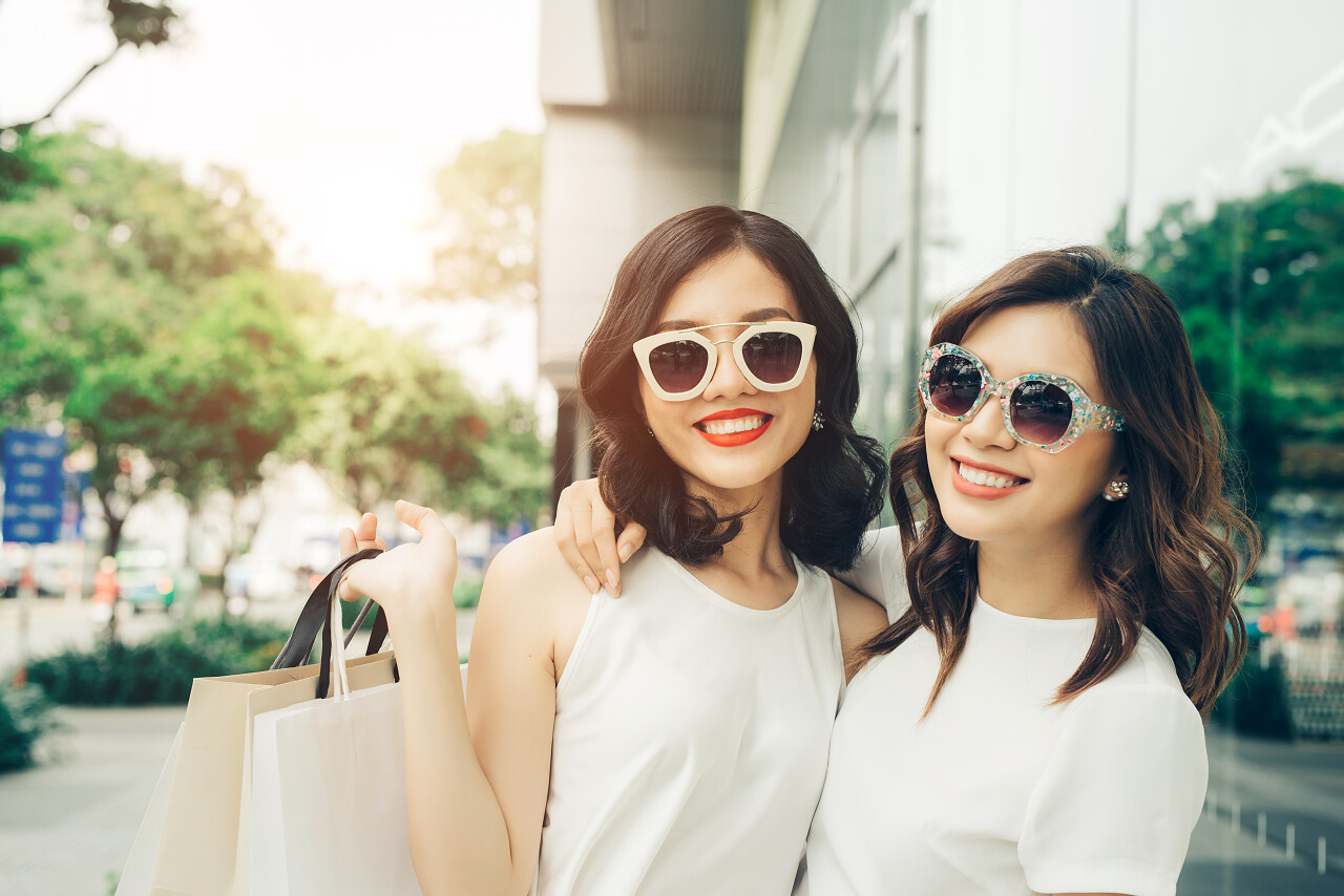 两个美丽的亚洲女孩走在商场外的大街上闺蜜