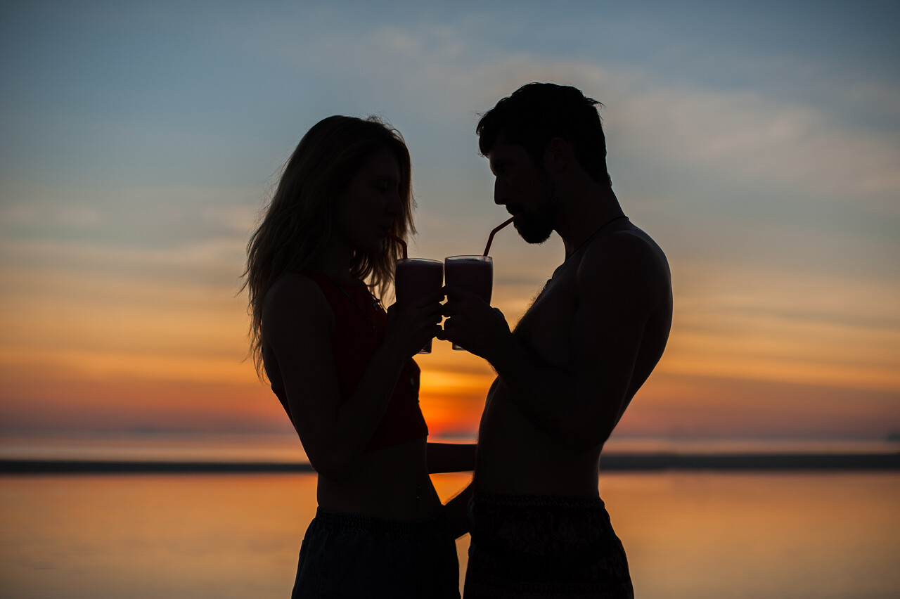 年轻夫妇站在海滩上在日落时分的鸡尾酒的剪影幸福婚姻情侣幸福情侣幸福的人七夕520情人节214情人节