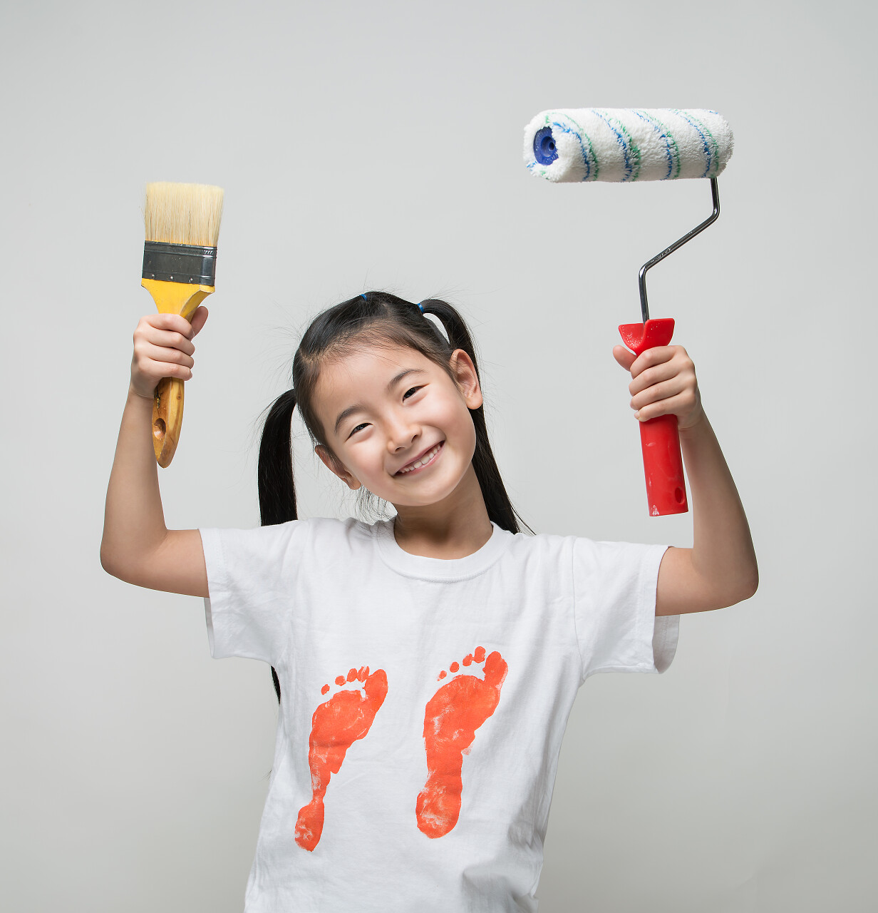 可爱的亚洲女孩抱着画笔和颜料