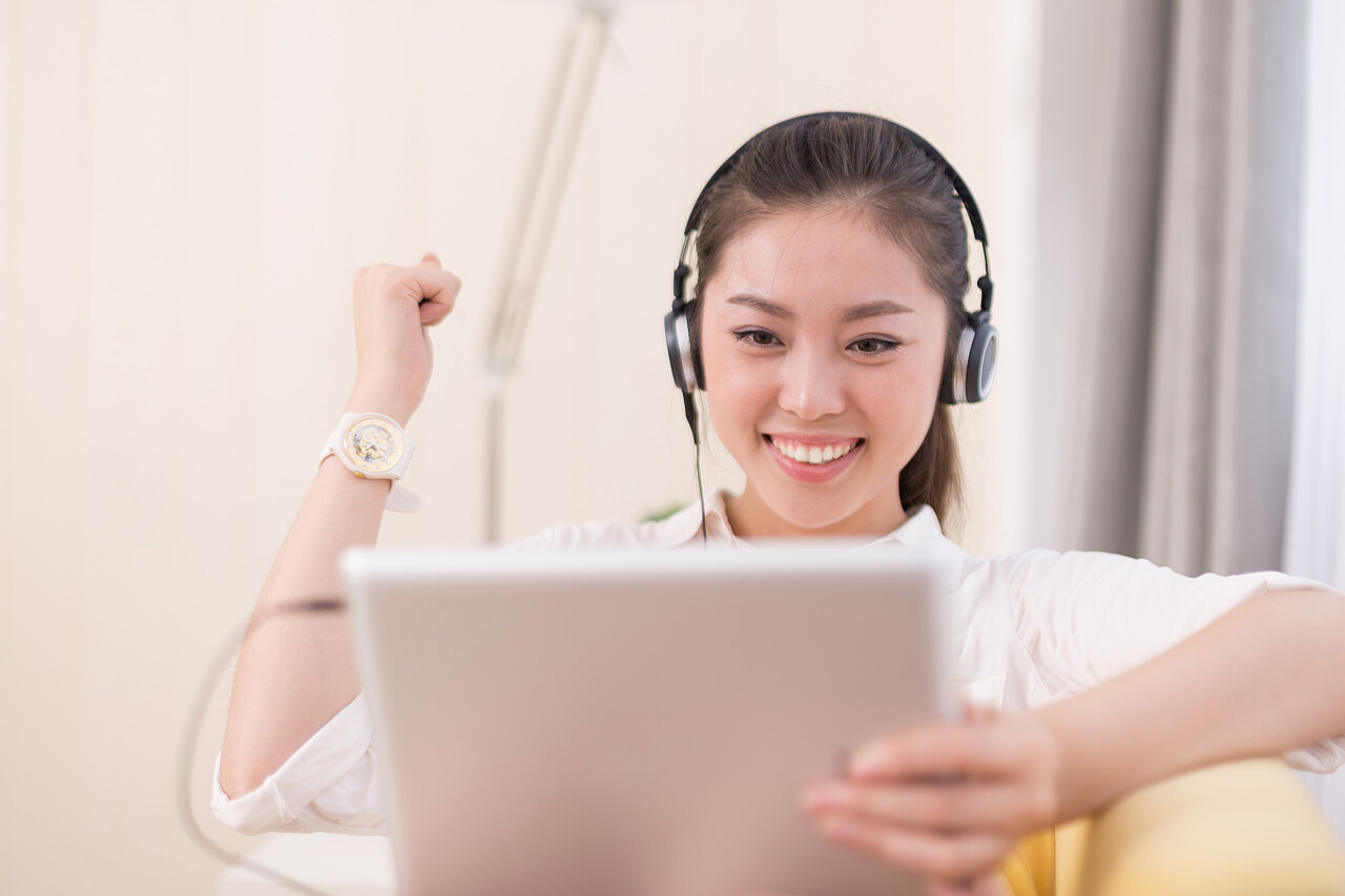 年轻漂亮的中国女人在房间里听音乐