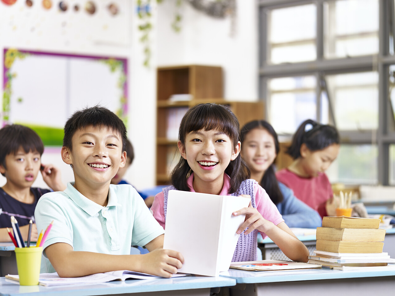 亚洲小学学生在教室里看着镜头微笑的画像.