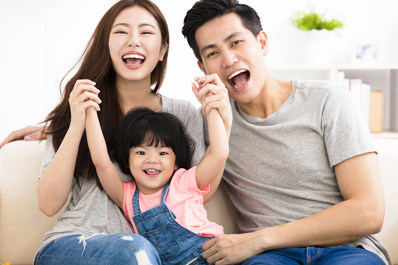 幸福的家庭与坐在沙发上玩的小女孩幸福一家人幸福家庭幸福的人微笑的小女孩笑脸笑容