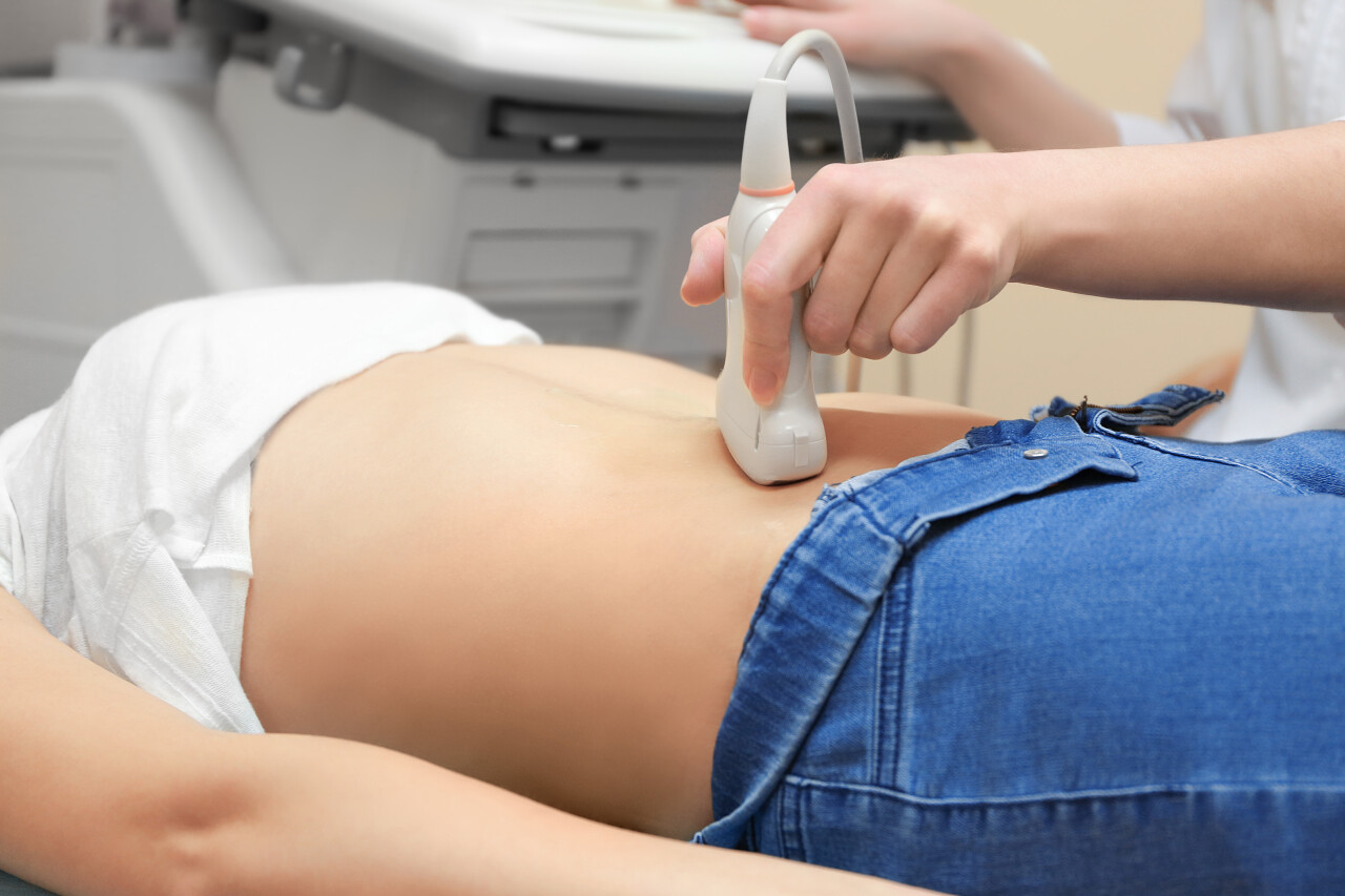 在现代诊所接受超声波扫描的年轻妇女