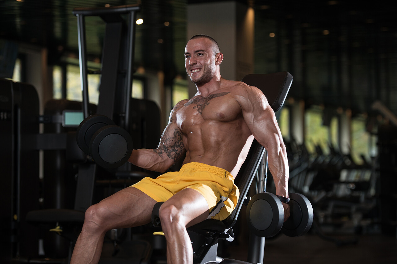 在健身房里锻炼二头肌的人