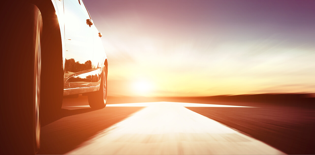 快速辆车在公路与日落