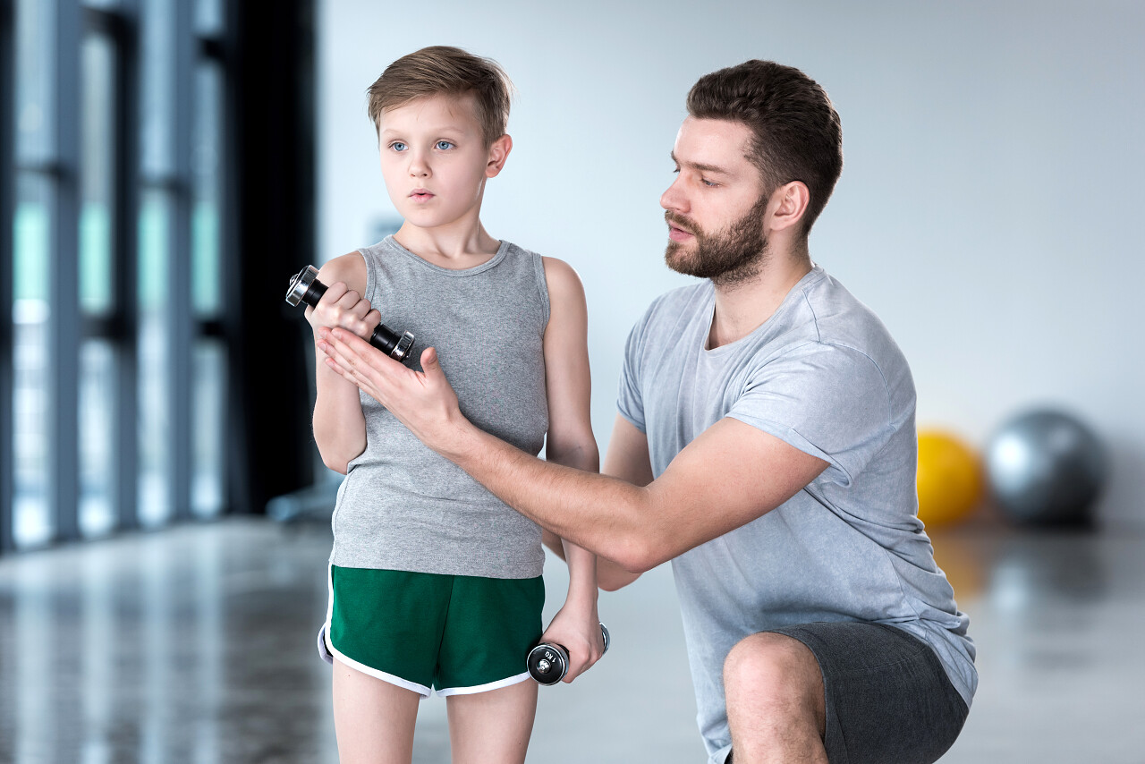 男孩的哑铃健身中心教练与培训
