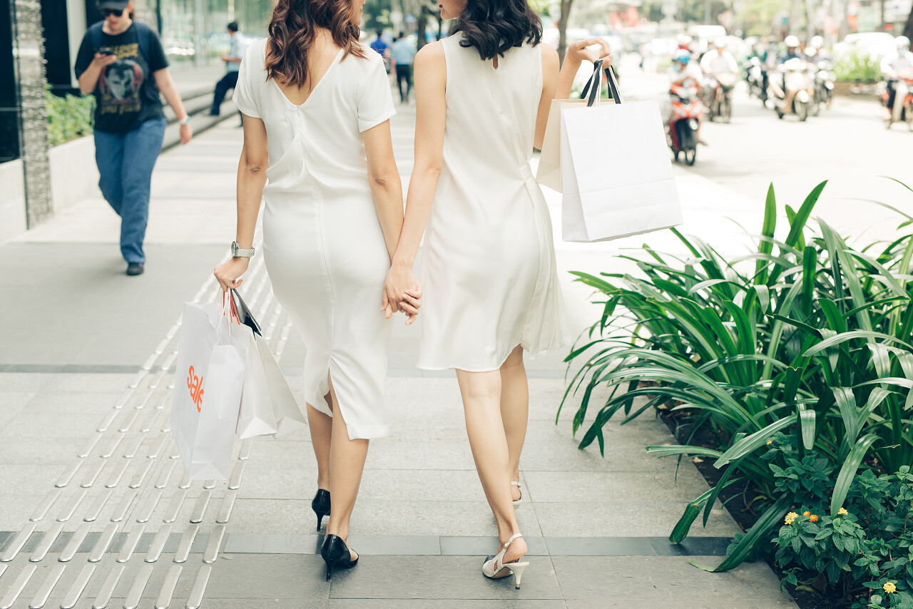 拿着购物袋走在街上的女孩闺蜜